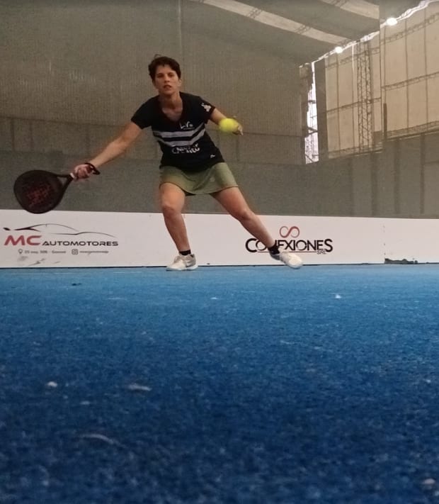 Jorgelina Ruiz jugando un punto de pádel, estirándose para devolver la pelota